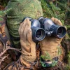 Spähender Soldat mit BelOMO Prismen-Fernglas / Binocular 7x42 im Gebüsch