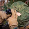 Spähender Soldat mit Zenit-BelOMO Militär-Fernglas / Binocular VKB7 im Wald